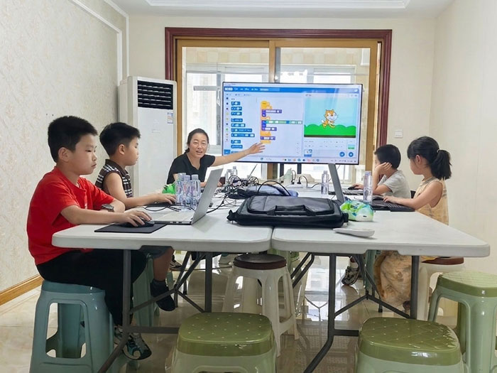 老师在给Scratch培训班小学员分析Scratch程序运行方法